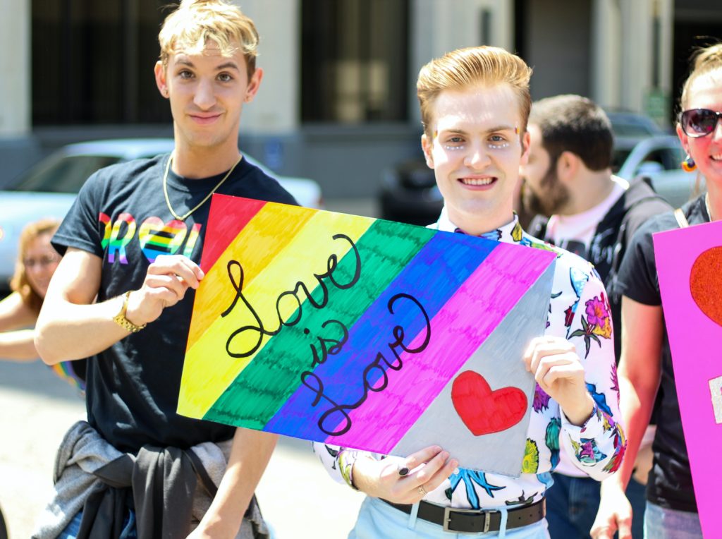 gay men holding love sign